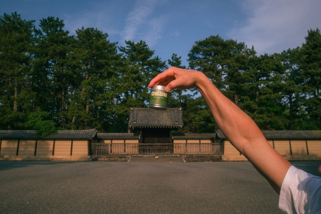 OSSU matcha held against a traditional Japanese temple backdrop