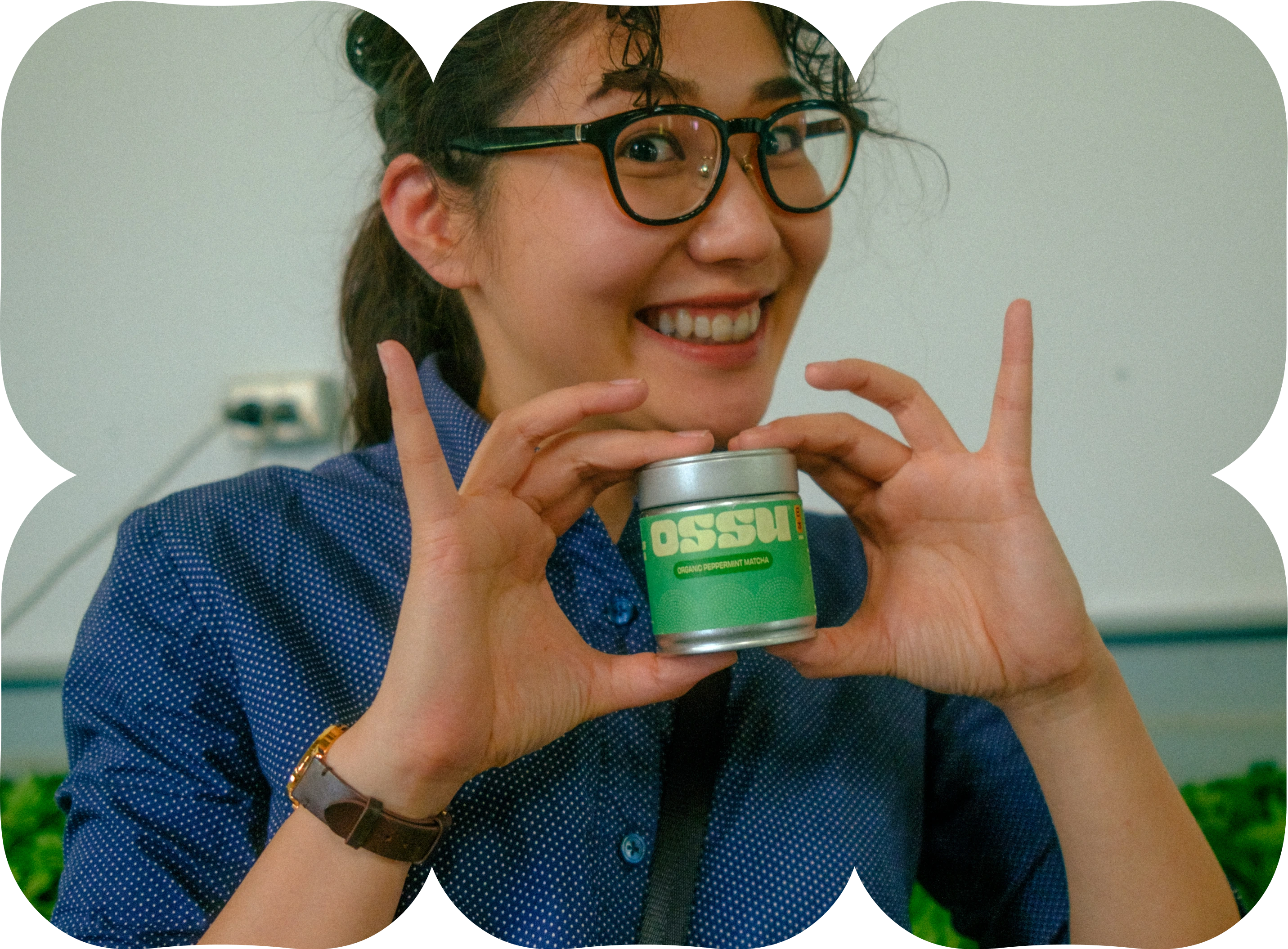 Smiling woman holding an OSSU matcha tin and presenting it to the camera