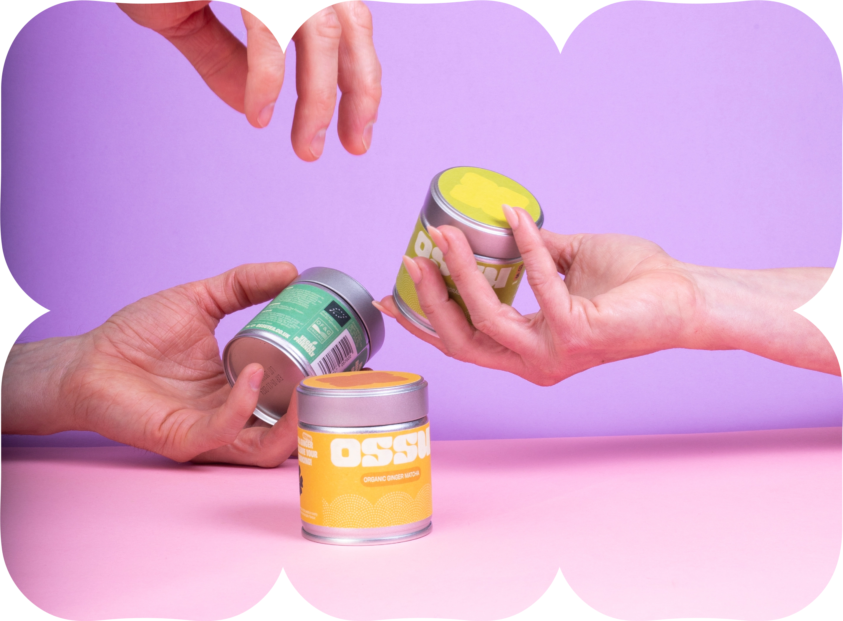 Hands passing colourful OSSU matcha tins between each other on a pastel background