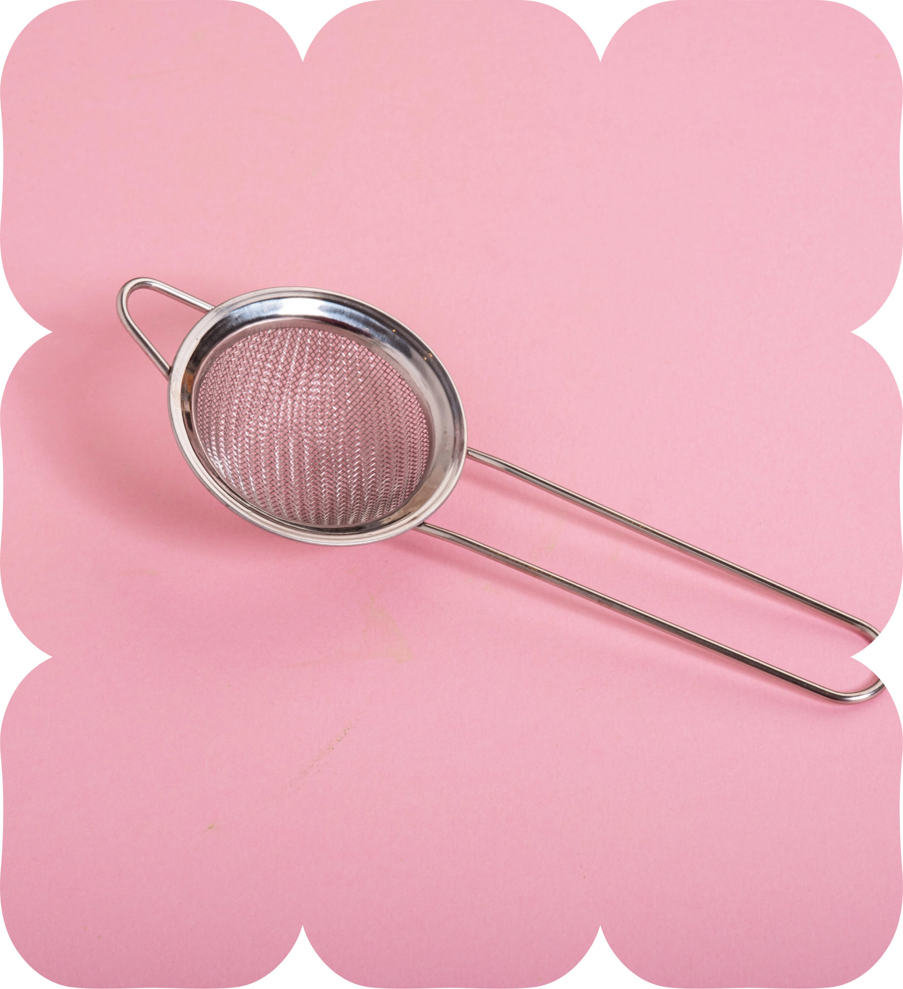 Stainless steel matcha sieve on a pink background.