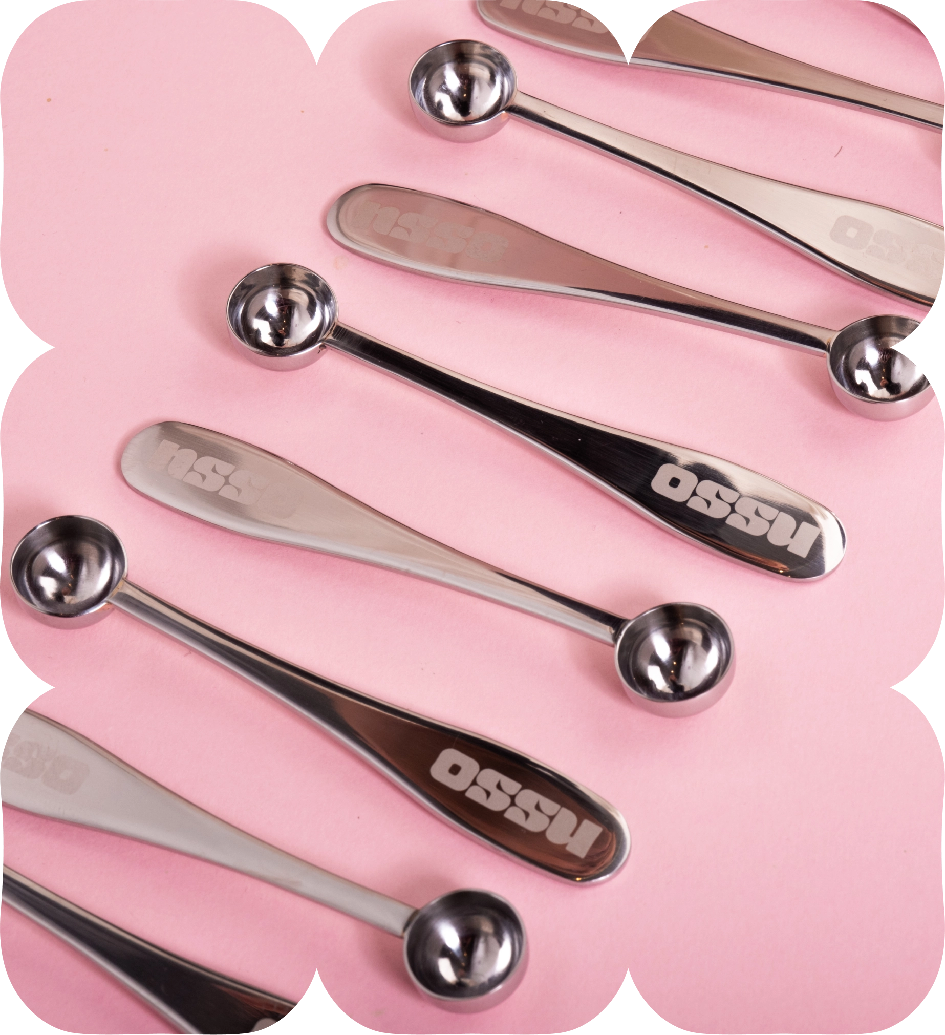 OSSU stainless steel matcha measuring spoons arranged in a row on a pink background