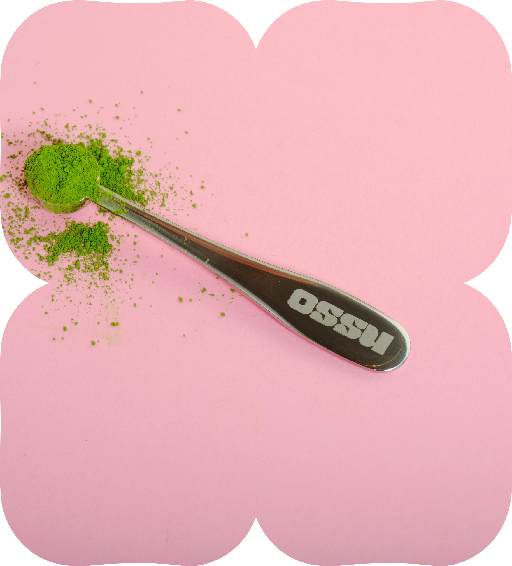 Metal 1g scoop filled with green matcha powder on a pink background