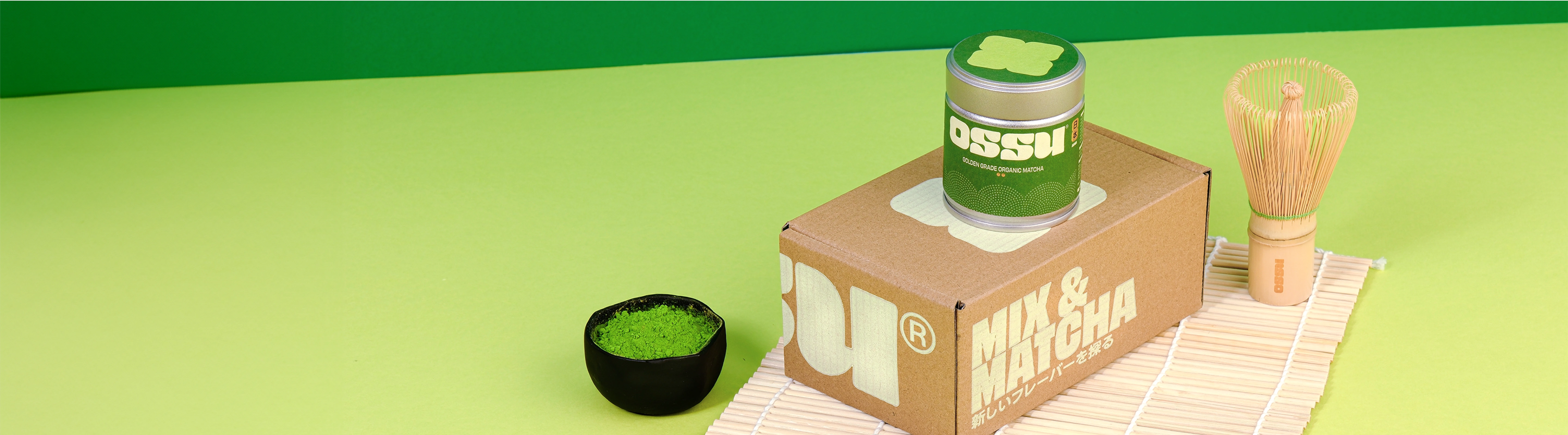 OSSU golden grade organic matcha tin on a box with matcha powder bowl and bamboo whisk