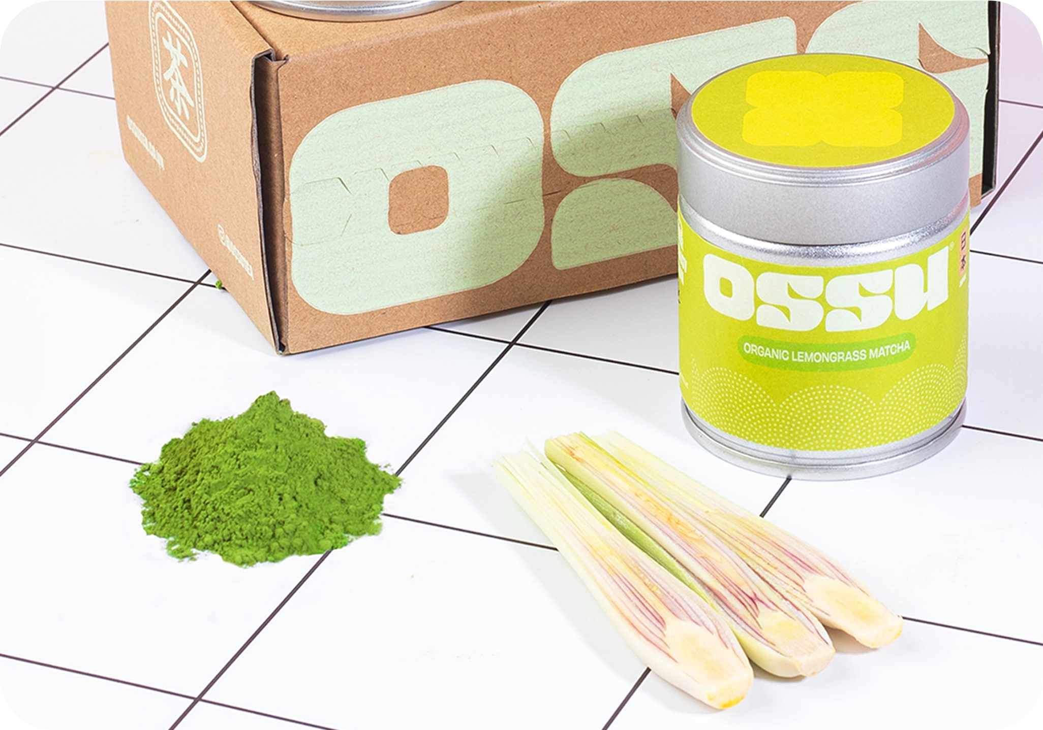 OSSU organic lemongrass matcha tin with loose matcha powder and fresh lemongrass beside OSSU box