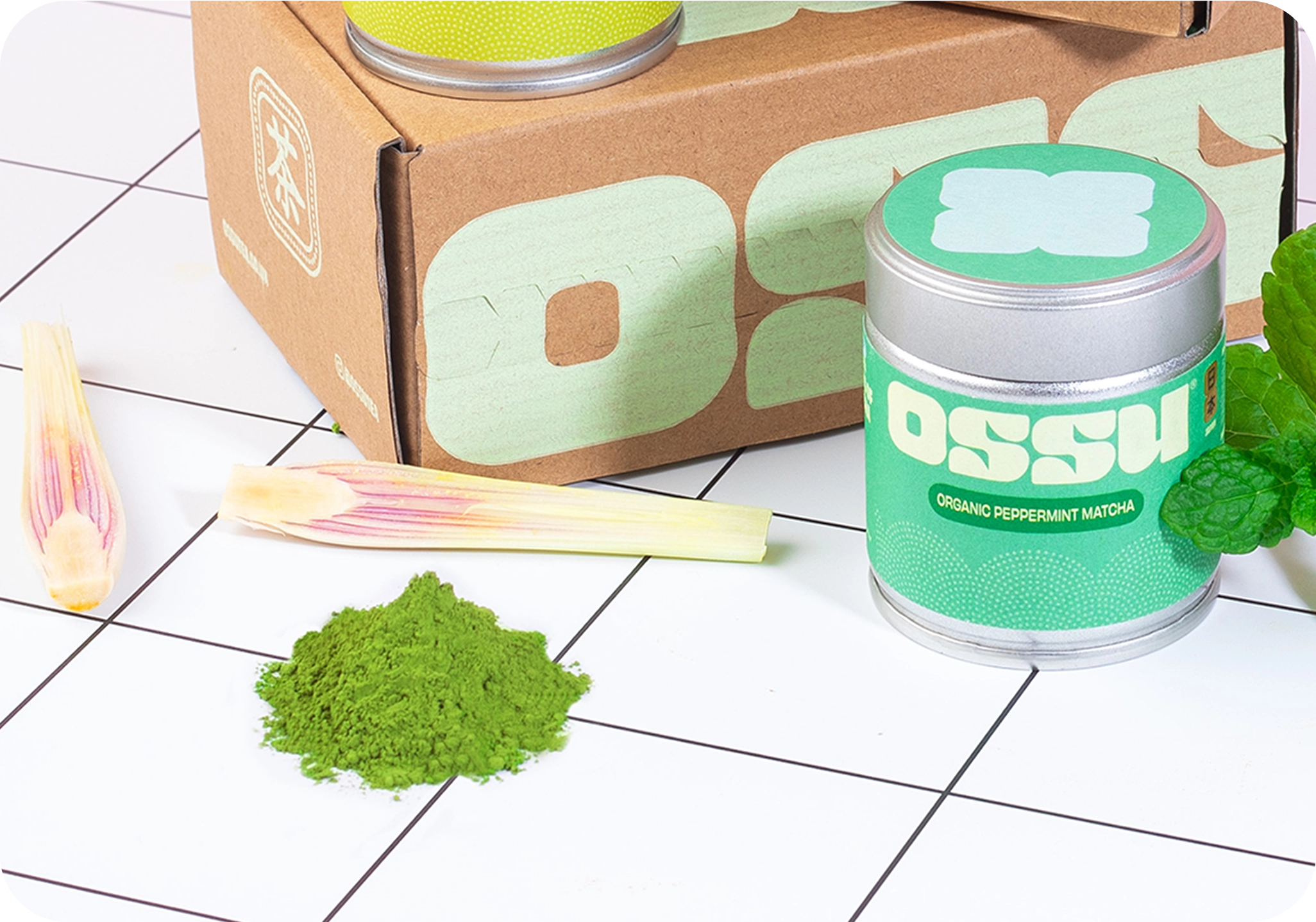 OSSU organic peppermint matcha tin with fresh mint, lemongrass and matcha powder beside OSSU branded box