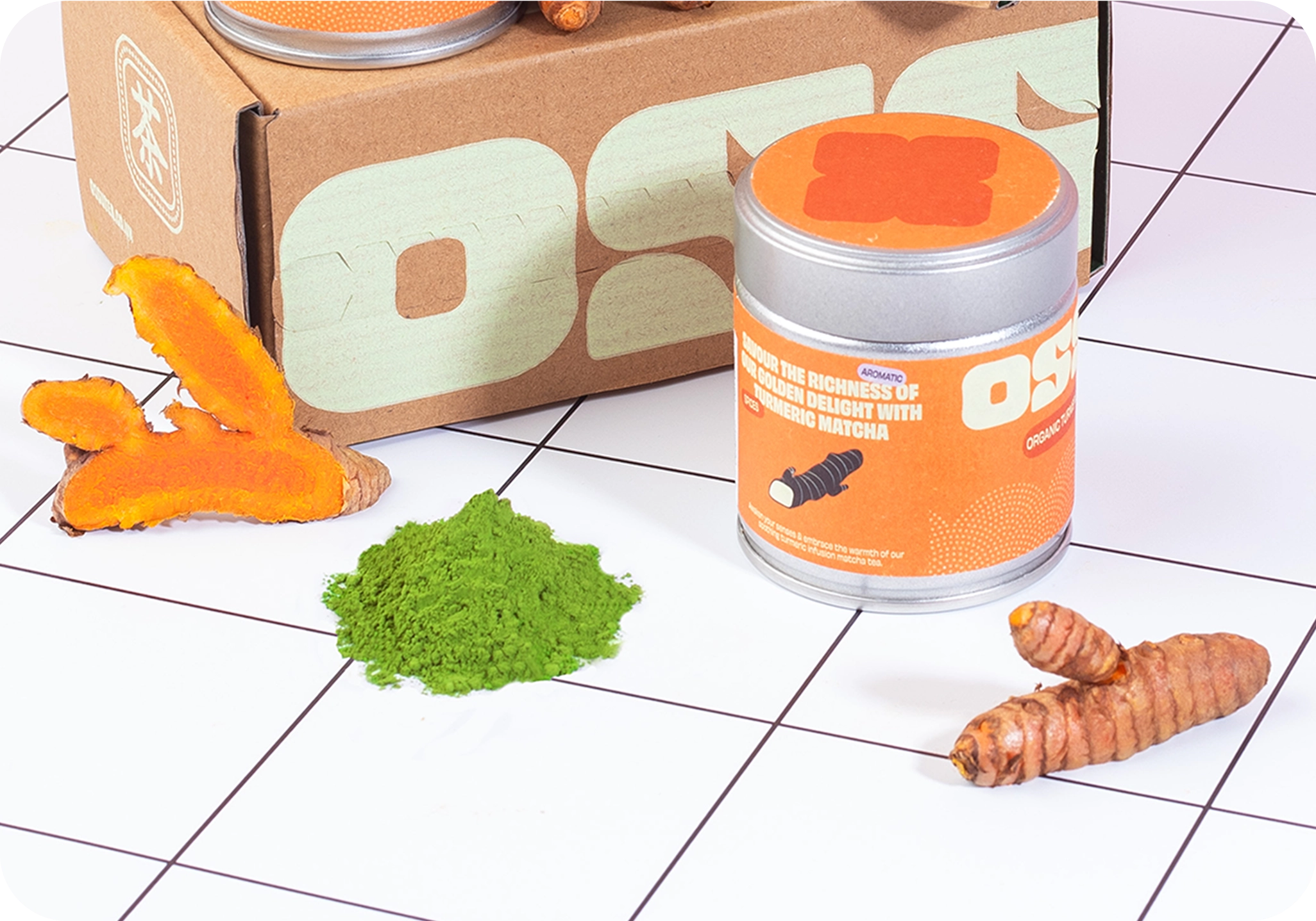 Close-up of OSSU organic turmeric matcha tin with fresh turmeric and matcha powder on a tiled surface